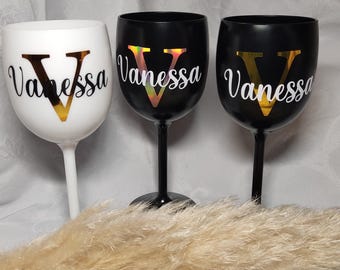 May include: Three stemmed wine glasses with black and white bases. Each glass has a gold vinyl decal with the name "Vanessa" and a large gold "V" initial.