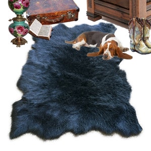 Op de afbeelding: Een donkerblauw nep bontkleed met een bruin-witte basset-hond die erop ligt.