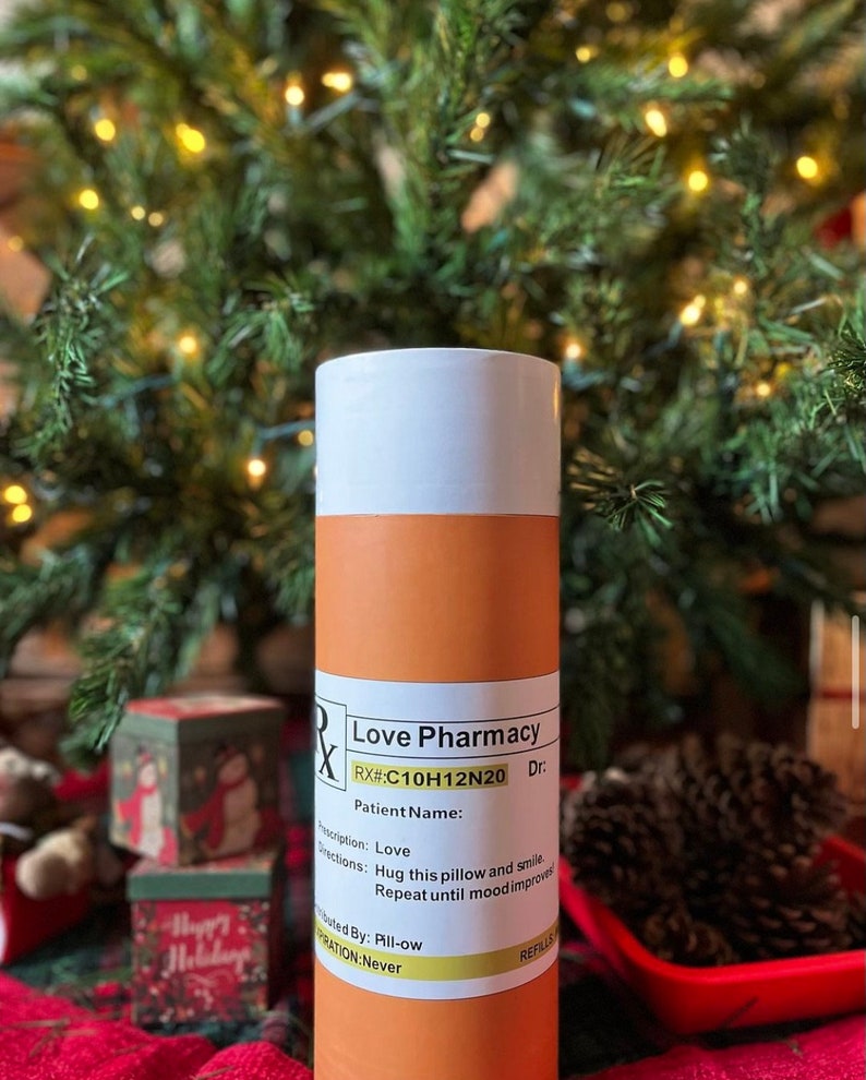 May include: Orange and white pill bottle with a label that reads "Love Pharmacy" and "RX#:C10H12N20". The label also includes the words "Patient Name", "Description: Love", "Directions: Hug this pillow and smile. Repeat until mood improves", "Distributed By: Pill-ow", and "Expiration: Never".