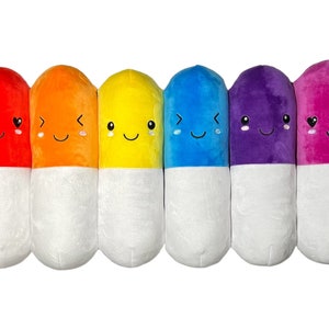 May include: Seven plush pill-shaped toys in a rainbow of colors, each with a different happy face. The pills are red, orange, yellow, blue, purple, and pink.