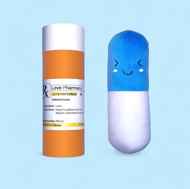 Soft cotton pill-shaped plushie with an embroidered face, featuring blue and white halves. Comes in a customizable prescription pill bottle with space for a Doctor and Patient name. Perfect for pharmacists, students, and couples.