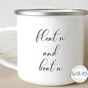 May include: White enamel mug with a silver rim and handle. The mug features the words "float n and boat n" in black script. A circular logo with the text "North 48 Trading Company" is on the lower right side.