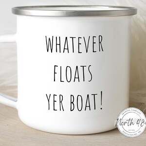 May include: White enamel mug with a silver rim and handle. The mug features the phrase "WHATEVER FLOATS YER BOAT!" in black lettering. A small circular logo is visible on the bottom right.