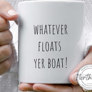 May include: White ceramic mug with the text "WHATEVER FLOATS YER BOAT!" in black. The mug also features a circular logo with the text "North 48 Trading Company" and "EST 2021 Restigouche, NB".