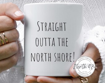 May include: White ceramic mug with the text "STRAIGHT OUTTA THE NORTH SHORE!" in black. The mug also features a circular logo with the text "North 48 Trading Company".