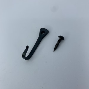 May include: A black metal hook with a screw for hanging items on a wall.