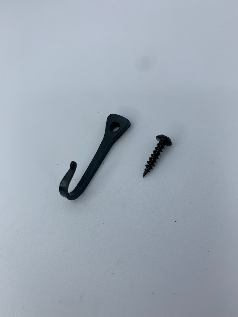 May include: A black metal hook with a screw for hanging items on a wall.