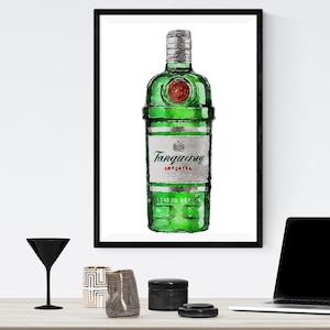 Op de afbeelding: Een ingelijst aquarel schilderij van een groene fles Tanqueray gin. De fles heeft een zilveren etiket met de merknaam en "IMPORTED" in rode tekst.