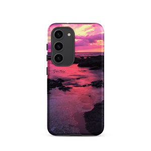 Può includere: Una custodia per telefono con un tramonto rosa e viola sull'oceano. La custodia ha un ritaglio per la fotocamera nero e il testo "Sara Marie Photography" in bianco.