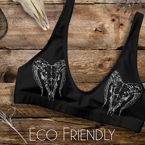 May include: Black sports bra with a white skull and horns graphic print. The text "ECO FRIENDLY" is printed below the graphic.
