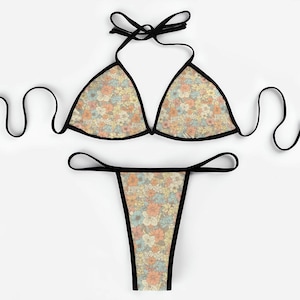 May include: A floral print bikini with black trim. The top is a triangle style with adjustable straps and the bottom is a cheeky style.