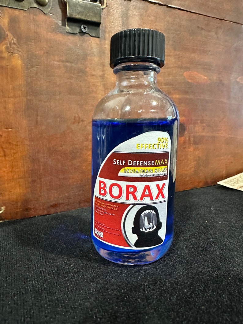 May include: A blue glass bottle with a red and white label that reads "90% EFFECTIVE SELF DEFENSE MAX LEVIATHAN KILLER" and "BORAX". The label also features a black silhouette of a person with a large mouth.