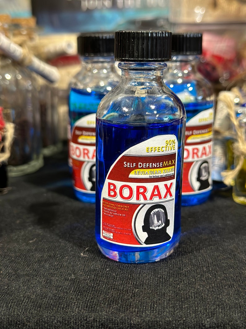 May include: A blue glass bottle with a black cap and a red and white label that reads "Self Defense Max Leviathan Killer 90% Effective Borax". The label also features a black silhouette of a person's head with a large mouth.