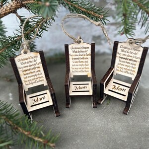 May include: Three wooden Christmas ornaments shaped like chairs, each with a jute string for hanging. The ornaments have the text "Christmas in Heaven" and a poem. The word "Mom" is displayed on each chair.