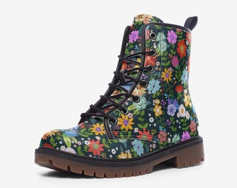 May include: An ankle-high lace-up boot featuring a dark green base with a vibrant, multi-colored floral pattern. The boot includes black laces, silver-toned metal eyelets, a black pull tab at the heel, and a thick, brown lugged rubber sole.
