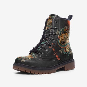 May include: Black combat boots featuring a tiger and snake tattoo design. The boots have a brown sole, black laces, and a pull tab. The artwork incorporates orange, teal, and yellow hues.