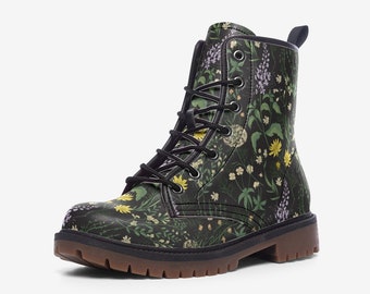 May include: A black combat boot with a floral pattern featuring yellow, white, and purple flowers. The boot has black laces, a brown sole, and a pull tab at the top. The overall design is a dark, botanical theme.