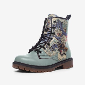May include: A light blue combat boot with a Japanese wave and dragon design. The boot has black laces, a brown sole, and a black trim. The design includes shades of blue, white, and red.