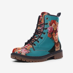Könnte beinhalten: Türkisfarbener Kampfstiefel mit floralem Design und einem Porträt einer Frau mit Blumen im Haar. Der Stiefel hat schwarze Schnürsenkel, eine braune Sohle und eine Zuglasche. Das Blumenmuster umfasst rote, rosa und gelbe Blumen.
