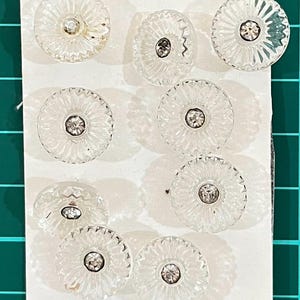Botões de vidro x9. Formato de flor transparente com centro de cristal.