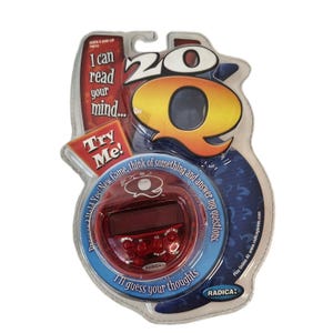 May include: A packaged "20Q" electronic game. The packaging is clear plastic with a blue and red design. The game features a red circular device with buttons and a screen, and the text "I can read your mind" and "Try Me!"