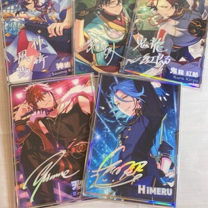 May include: Five holographic cards featuring anime characters with colorful backgrounds and signatures. The characters are dressed in different outfits and have different hairstyles. The cards are all in a clear plastic sleeve.