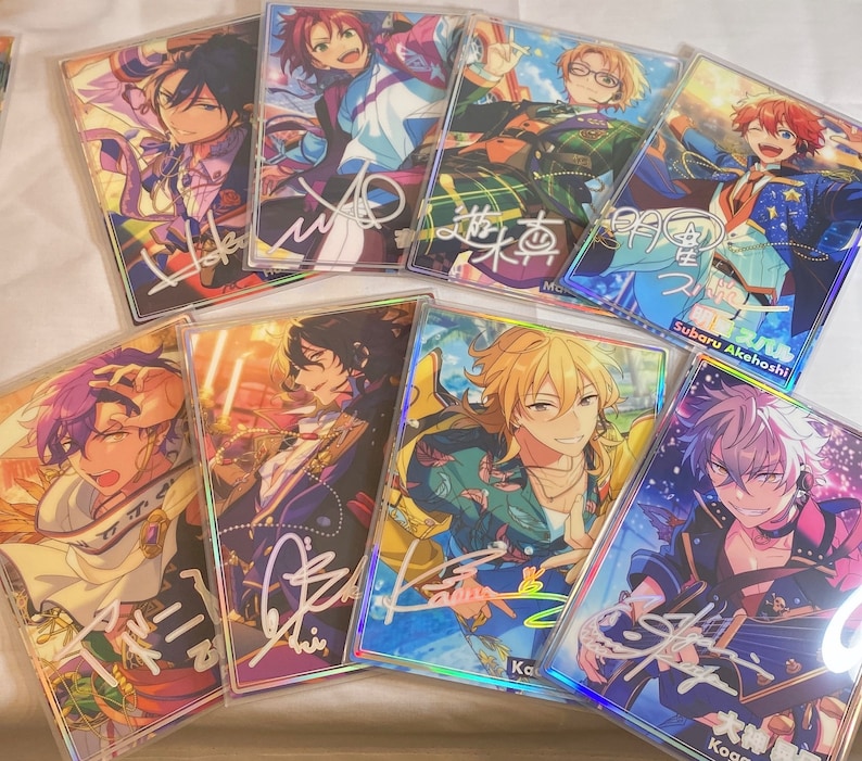 May include: A collection of eight holographic cards featuring anime characters with colorful backgrounds and signatures. The cards are in a variety of poses and expressions. The cards are all different sizes and shapes.