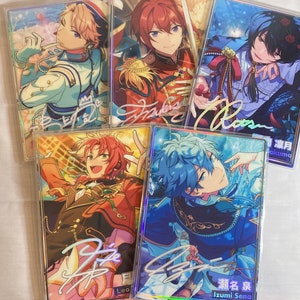 May include: Five holographic cards featuring anime characters with colorful backgrounds and signatures. The characters are dressed in different outfits and have different hair colors. The cards are all in a vertical format and have a white border.