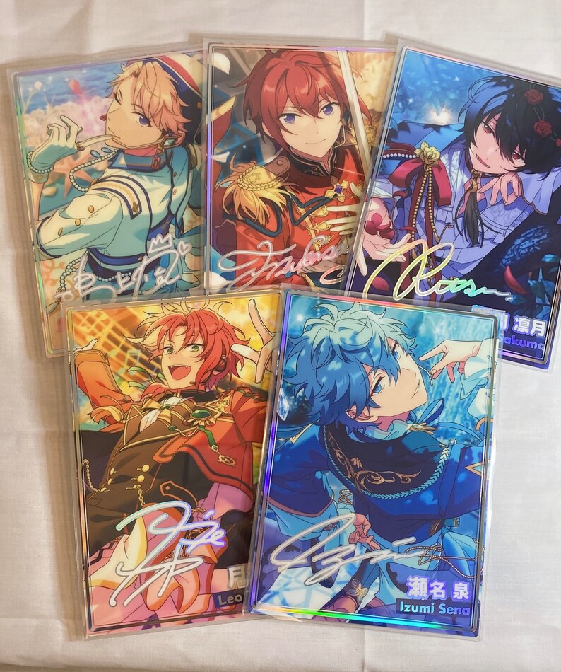 May include: Five holographic cards featuring anime characters with colorful backgrounds and signatures. The characters are dressed in different outfits and have different hair colors. The cards are all in a vertical format and have a white border.