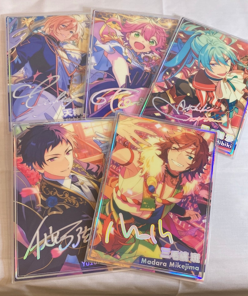 May include: Five colorful cards with holographic borders featuring anime characters. Each card has a signature and a name in Japanese. The characters are:  Hibiki, Madara Mikejima, Yuzuru,  Tsumugi, and  Aoi.