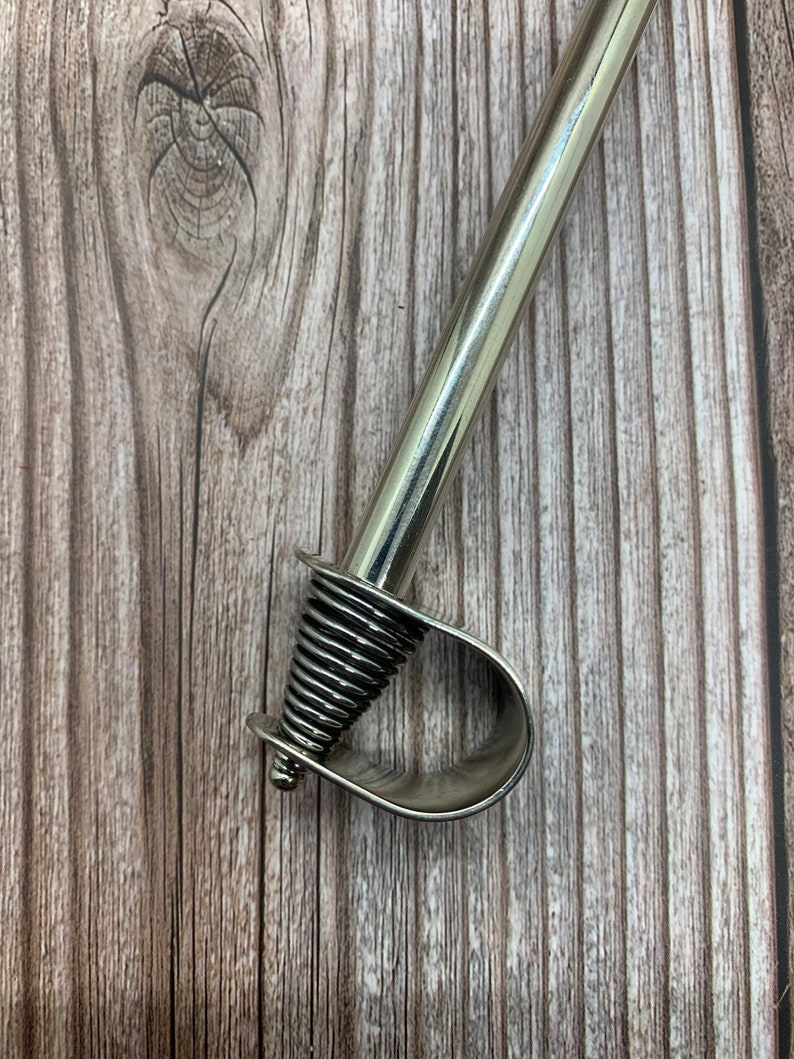 May include: A silver metal curtain rod finial with a spiral design.
