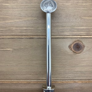 May include: A silver metal door handle with a horse head design on the top and a spiral design on the bottom.