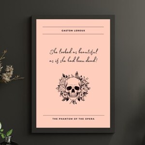 May include: A pink printable poster with a black skull surrounded by flowers. The text on the poster reads "GASTON LEROUX", "She looked as beautiful as if she had been dead!" and "THE PHANTOM OF THE OPERA".