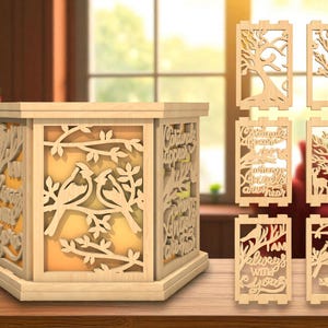 Peut inclure: Une lanterne en bois avec des motifs découpés de détails, représentant des oiseaux, des branches et du texte. Des panneaux interchangeables supplémentaires avec des motifs d'arbres et d'oiseaux sont inclus. La lanterne dégage une lueur chaleureuse.