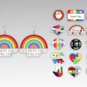 Puede incluir: Una colección de coloridos pines y pendientes. Los pendientes tienen forma de arcoíris con el texto "SOUNDS GAY I'M IN." Otros pines incluyen frases como "Super Gay", "Neurodivergent" y "Autism".