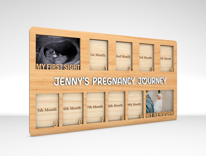 K&ouml;nnte beinhalten: Ein Holzfotorahmen mit neun Pl&auml;tzen f&uuml;r Bilder, beschriftet mit den Monaten der Schwangerschaft. Der Rahmen tr&auml;gt den Text "My First Sight" und "Jenny's Pregnancy Journey". Der Rahmen ist so konzipiert, dass er Ultraschallbilder und Fotos eines Babys aufnehmen kann, das w&auml;hrend der Schwangerschaft w&auml;chst.