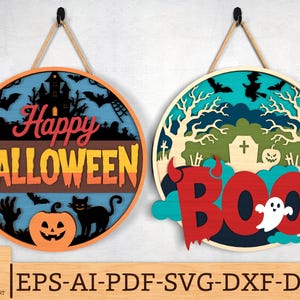 Puede incluir: Dos letreros redondos de madera con temática de Halloween. Uno dice "Happy Halloween" con una casa embrujada y una calabaza. El otro dice "BOO" con un fantasma y un cementerio. Ambos letreros tienen una cuerda para colgar.