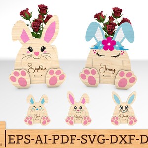 Può includere: Quattro vasi di fiori in legno a forma di coniglio con nomi personalizzati. I vasi sono dipinti in tonalità di legno chiaro e hanno orecchie di coniglio rosa. I nomi "Sophia", "Jenny", "Jark" e "Dachd" sono incisi sulla parte anteriore dei vasi.