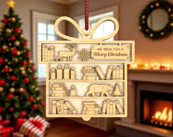 May include: Wooden Christmas ornament in the shape of a gift box, featuring shelves with books, candles, and festive cutouts. The ornament includes a deer, bear, snowflake, and the text "WE WISH YOU A Merry Christmas."