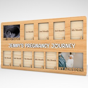 K&ouml;nnte beinhalten: Ein Holzrahmen mit neun Bildpl&auml;tzen, der dazu bestimmt ist, eine Schwangerschaftsreise zu dokumentieren. Der Rahmen tr&auml;gt den Text "My First Sight" und "Jenny's Pregnancy Journey". Der Rahmen tr&auml;gt auch den Text "My Newborn".