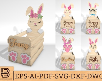 Könnte beinhalten: Osterkorb aus Holz mit Hasenmotiv. Der Korb zeigt ein Hasengesicht mit Blumenkranz, Pfotenabdrücken und dem Namen "Jenny". Zusätzliche Designs umfassen Hasen mit Brille, Schleifen und dem Text "Happy Easter".