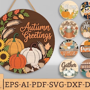 Può includere: Un cartello rotondo in legno con la scritta "Autumn Greetings" e decorazioni a tema autunnale. Il cartello presenta girasoli, zucche e ghiande nei toni dell'arancione, del giallo e del bianco. Sono mostrati anche altri cartelli rotondi a tema autunnale.