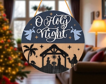May include: Round wooden Christmas sign with the words "O Holy Night" in white script. The sign features a nativity scene silhouette and two angel figures. The sign is two-toned, with a navy blue top and a light wood bottom.