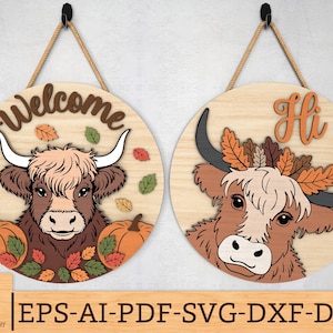 Könnte beinhalten: Zwei runde Holzschilder mit Highland-Kuh-Designs. Eines zeigt "Welcome" und hat Kürbisse und Herbstblätter. Das andere zeigt "Hi" und hat eine Kuh mit einem Blätterkranz. Beide Schilder hängen an einem Seil.