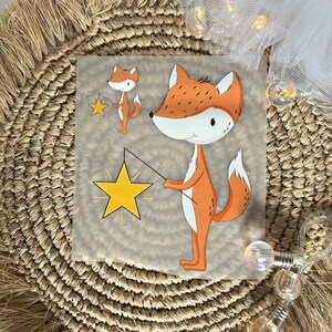 Könnte beinhalten: Zwei orangefarbene Füchse mit weißen Gesichtern und schwarzen Augen halten gelbe Sterne an Stöcken. Die Füchse befinden sich auf einem transparenten Hintergrund.