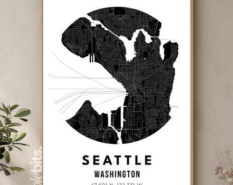 May include: A framed black and white map print of Seattle, Washington. The city map is contained within a circular shape. The city name and state are printed in a bold, sans-serif font below the map, along with the coordinates 47.60° N, 122.33° W.