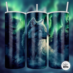May include: A stainless steel tumbler with a wolf and aurora borealis design. The wolf is gray and white, and the aurora borealis is green and blue. The tumbler is surrounded by a dark forest.
