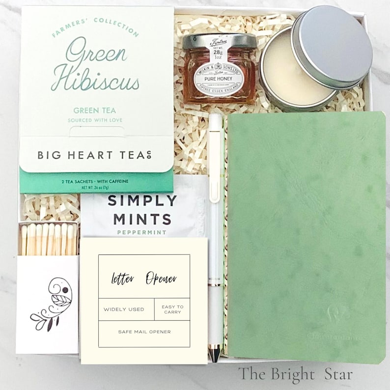 Pode incluir: Caixa de presente com ch&aacute; Green Hibiscus, um pequeno pote de mel, b&aacute;lsamo labial, um caderno verde, uma caneta, mentas, um abridor de cartas e f&oacute;sforos. A caixa &eacute; preenchida com papel. O pote de mel tem 28g.