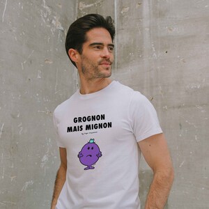 Puede incluir: Camiseta blanca con un personaje de dibujos animados morado y el texto "GROGNON MAIS MIGNON" impreso en la parte delantera.