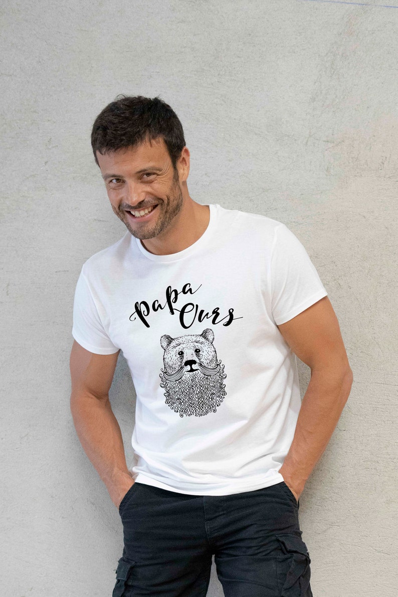 May include: White t-shirt featuring a black and white illustration of a bear with a beard and moustache. The text "Papa Ours" is written above the bear.
